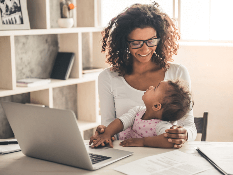 Mom working on laptop with baby on lap