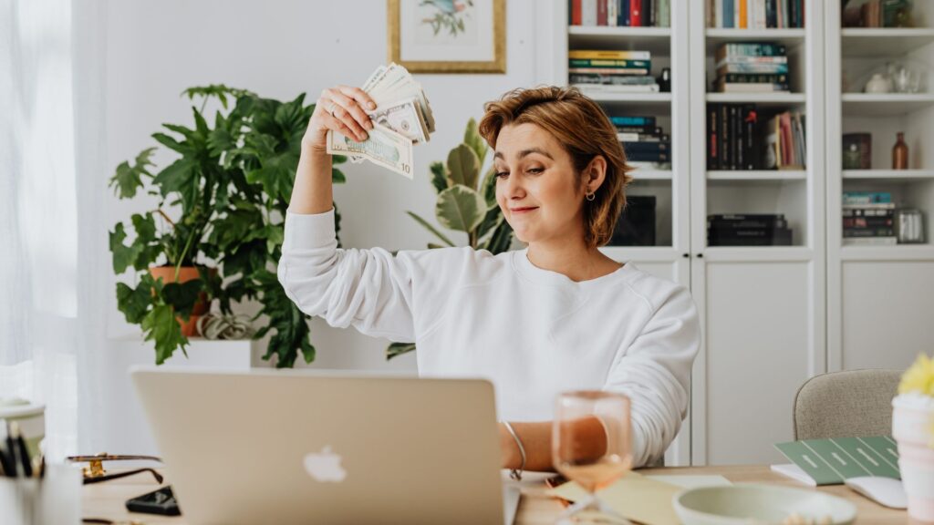 Work from home woman waving money