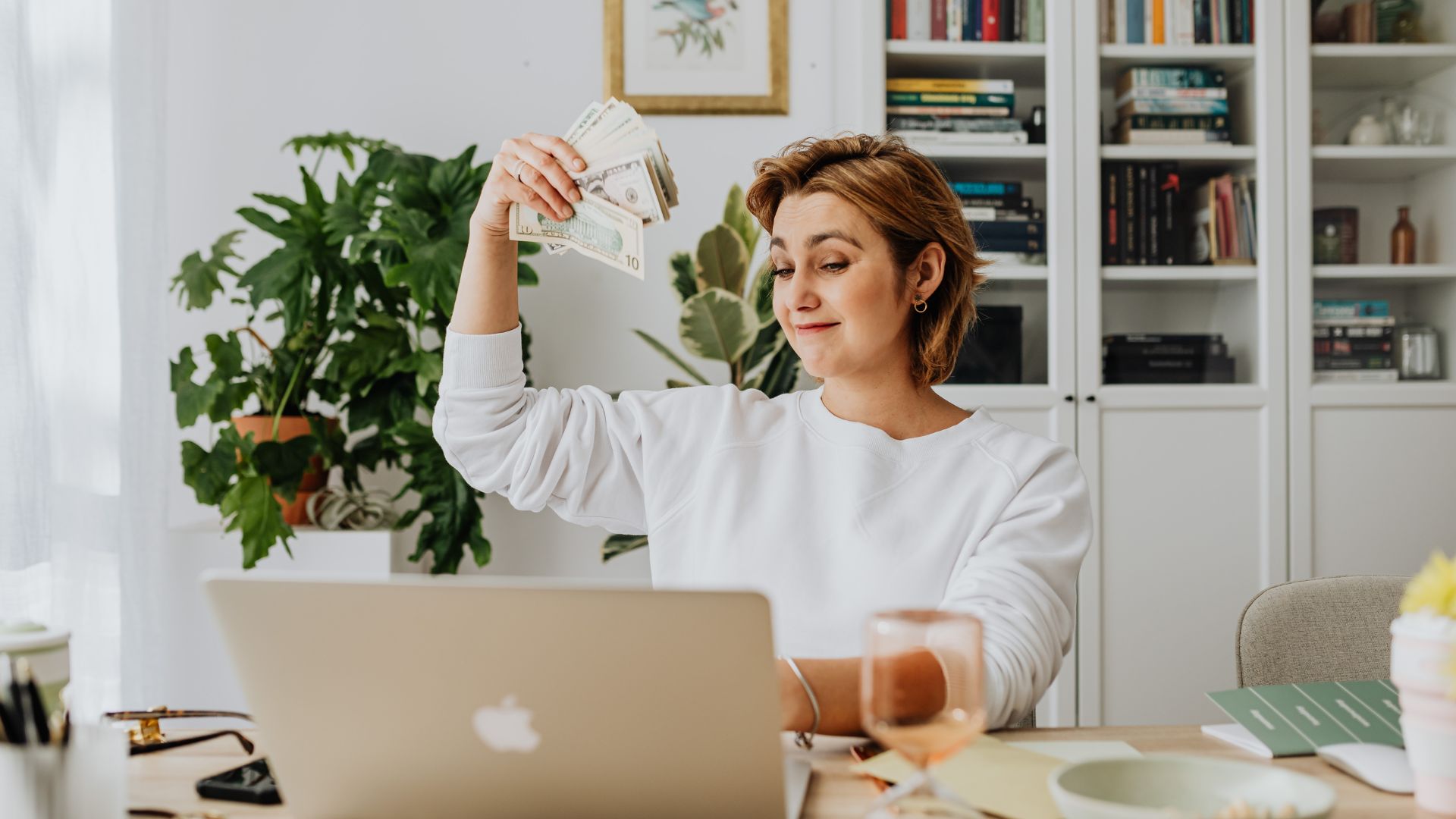 Work from home woman waving money