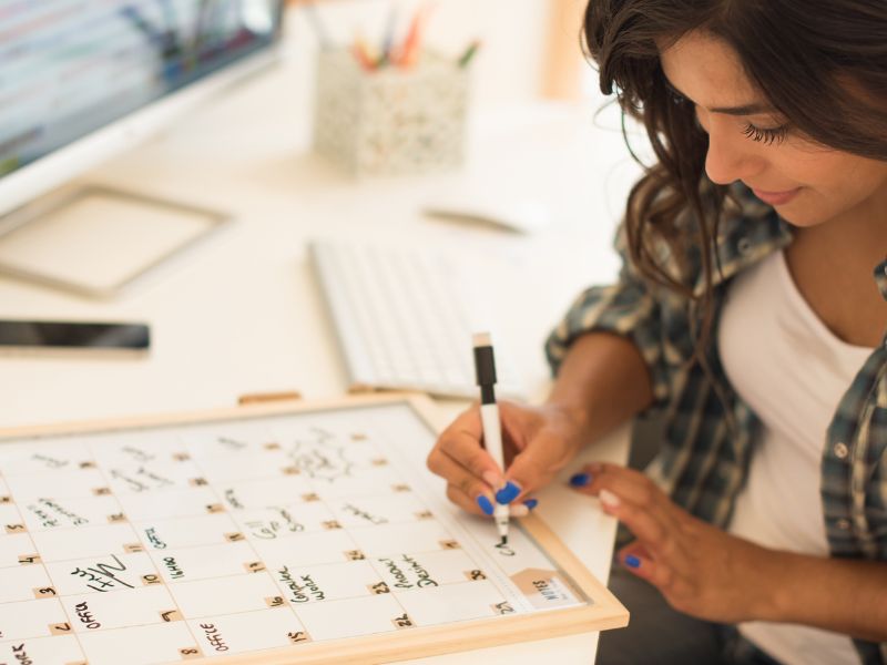 Woman writing on calendar